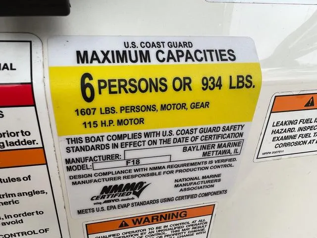 Slide: The Image of Bayliner T18BAY 2021 capacity label: 6 persons or 934 lbs, 115 HP motor. - 23