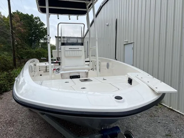Slide: The Image of 2021 Bayliner T18BAY boat, white exterior, parked near a metal building. - 3