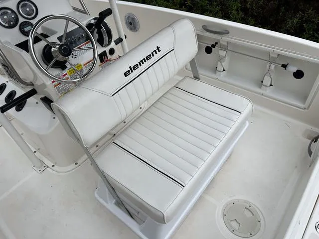 Slide: The Image of 2021 Bayliner T18BAY boat interior with white seating and steering console. - 8