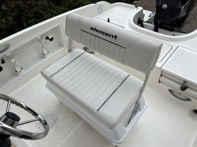 Slide: The Image of 2021 Bayliner T18BAY boat interior with white cushioned seating and steering wheel. - 9