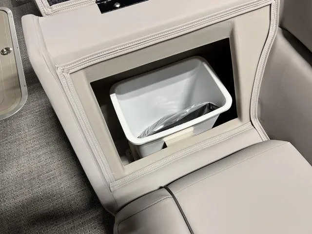 Slide: The Image of 2025 Barletta Aria A24QC boat interior with built-in storage compartment and trash bin. - 21