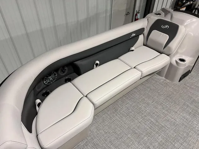Slide: The Image of 2025 Barletta Aria A24QC boat interior with plush seating and cup holders. - 22