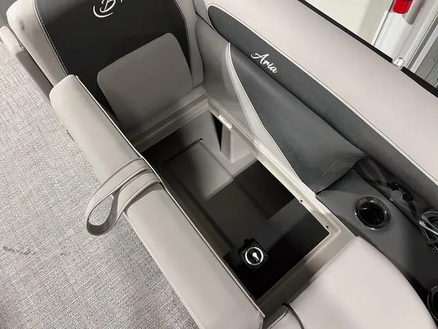 Slide: The Image of 2025 Barletta Aria A24QC boat seat storage compartment with cup holder and sleek design. - 6