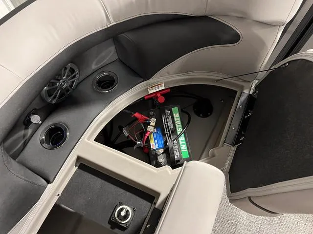 Slide: The Image of 2025 Barletta Aria A24QC boat interior with battery compartment and cup holders. - 7