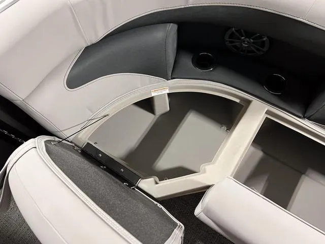 Slide: The Image of 2025 Barletta Aria A24QC boat interior storage compartment with cup holders and speaker. - 9