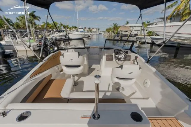 Slide: The Image of 2022 Starcraft SVX 190 DC boat interior with seating, steering wheel, and waterfront view. - 5