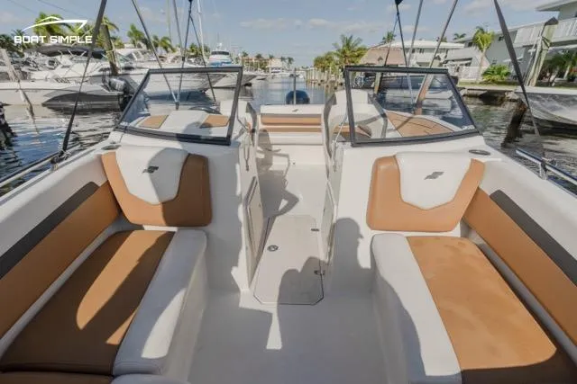 Slide: The Image of 2022 Starcraft SVX 190 DC boat interior with tan and white seating, docked in a marina. - 9
