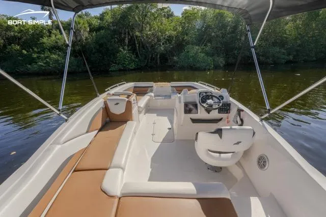 Slide: The Image of 2022 Starcraft SVX 191 OB boat interior with seating and steering, on a calm river. - 4