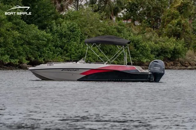 Slide: The Image of 2022 Starcraft SVX 211 OB boat on water, surrounded by lush greenery. - 1