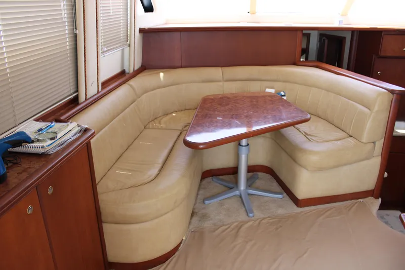 Slide: The Image of Luxurious interior of 2006 Silverton 42 Convertible yacht with beige seating and wooden table. - 15