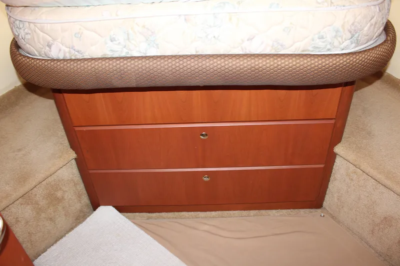 Slide: The Image of 2006 Silverton 42 Convertible cabin with wooden drawers under a bed. - 19