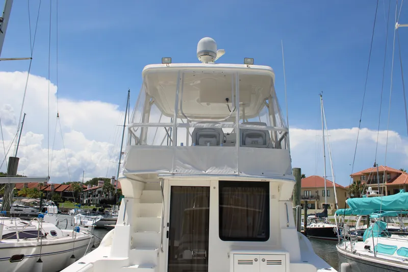 Slide: The Image of 2006 Silverton 42 Convertible yacht docked at marina under clear blue sky. - 2