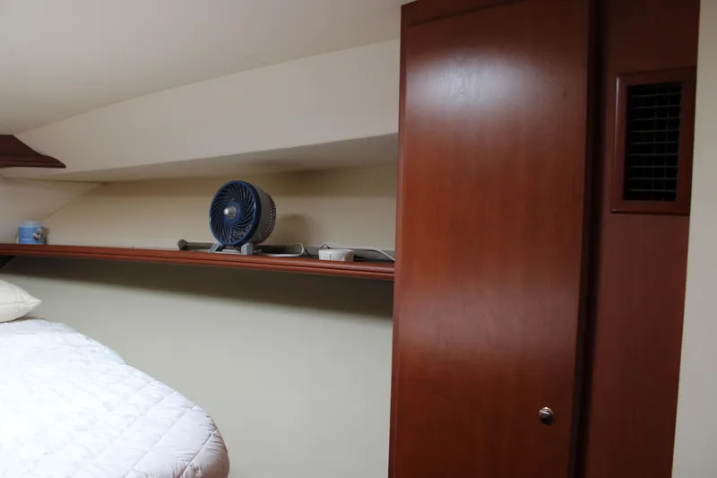 Slide: The Image of 2006 Silverton 42 Convertible cabin interior with wooden cabinetry and shelf fan. - 20