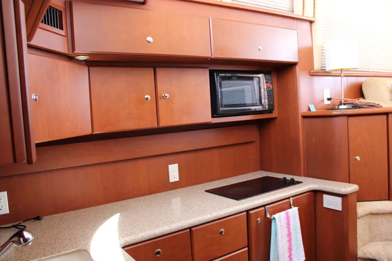 Slide: The Image of 2006 Silverton 42 Convertible yacht kitchen with wooden cabinets and modern appliances. - 22