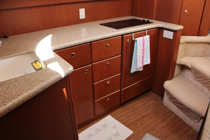 Slide: The Image of 2006 Silverton 42 Convertible yacht kitchen with wooden cabinets and countertop. - 42