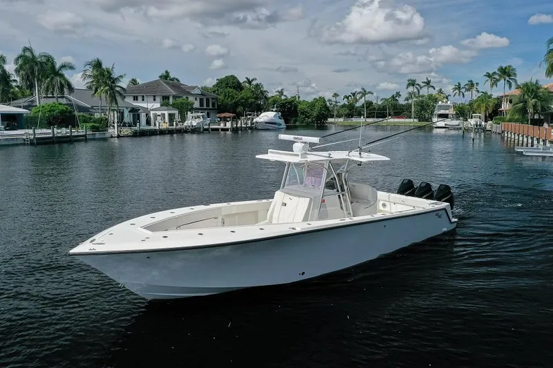 Slide: The Image of 2021 SeaVee 370z boat cruising on a scenic waterway with palm trees. - 2