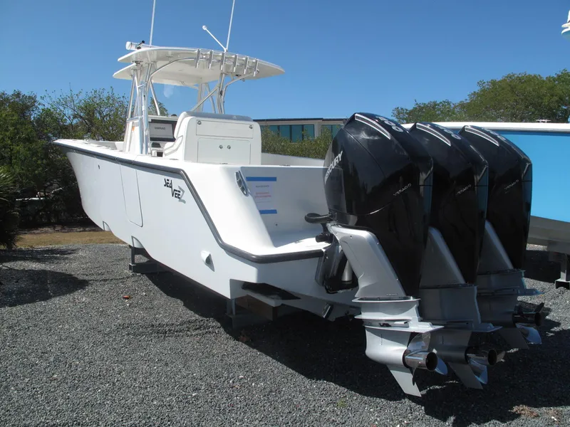 Slide: The Image of 2021 SeaVee 370z boat with triple outboard engines, parked on gravel. - 21