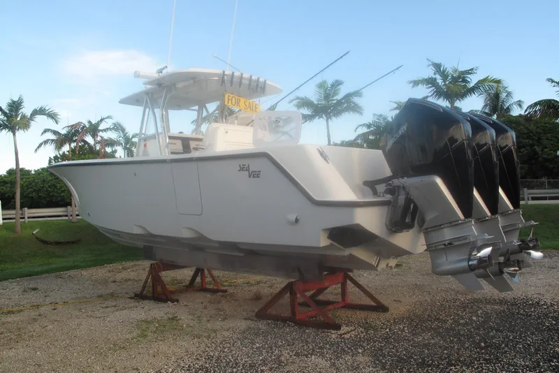 Slide: The Image of 2021 SeaVee 370z boat with triple engines, displayed for sale on stands, surrounded by palm trees. - 27