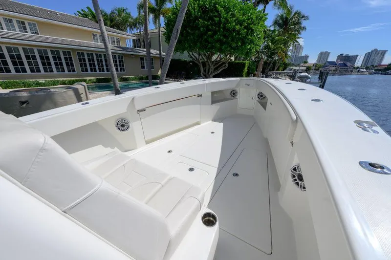 Slide: The Image of 2021 SeaVee 370z boat with spacious deck and seating, docked by waterfront homes. - 6