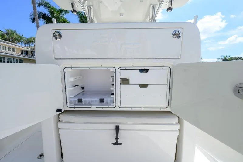 Slide: The Image of 2021 SeaVee 370z boat storage compartments open under sunny sky. - 9