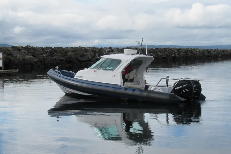 Slide: The Image of 2007 Protector Targa 28 boat on calm water with Mercury outboard engines. - 11