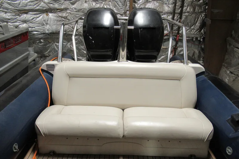 Slide: The Image of 2007 Protector Targa 28 boat interior with white seating and dual engines. - 2