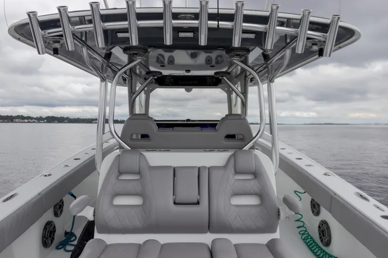 Slide: The Image of Freeman 42LR 2020 boat interior with gray seating and rod holders on a cloudy day. - 9