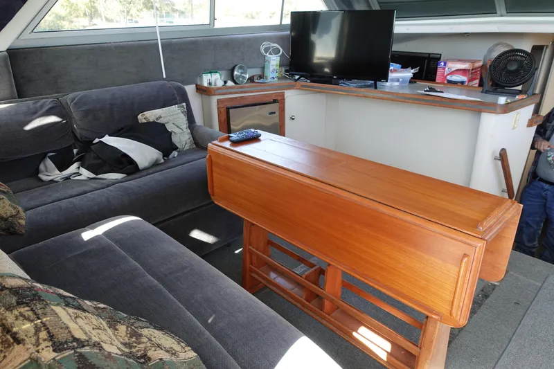 Slide: The Image of Interior of 1988 Trojan 10.8 Meter Sedan with sofa, wooden table, and TV. - 23