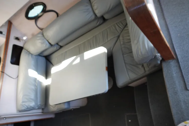 Slide: The Image of 1988 Trojan 10.8 Meter Sedan interior with gray seating and table. - 27