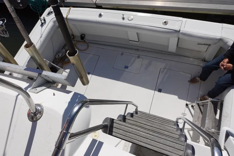 Slide: The Image of 1988 Trojan 10.8 Meter Sedan boat deck with fishing rod holders and seating area. - 6
