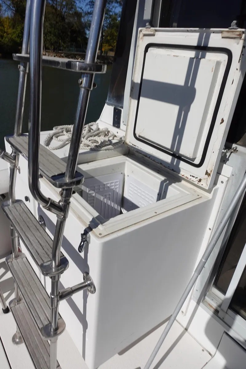 Slide: The Image of 1988 Trojan 10.8 Meter Sedan boat with open storage compartment and ladder. - 13