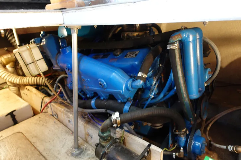 Slide: The Image of Engine compartment of a 1988 Trojan 10.8 Meter Sedan boat, showcasing blue engine components. - 16