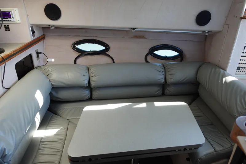 Slide: The Image of 1988 Trojan 10.8 Meter Sedan interior with gray leather seating and table. - 19