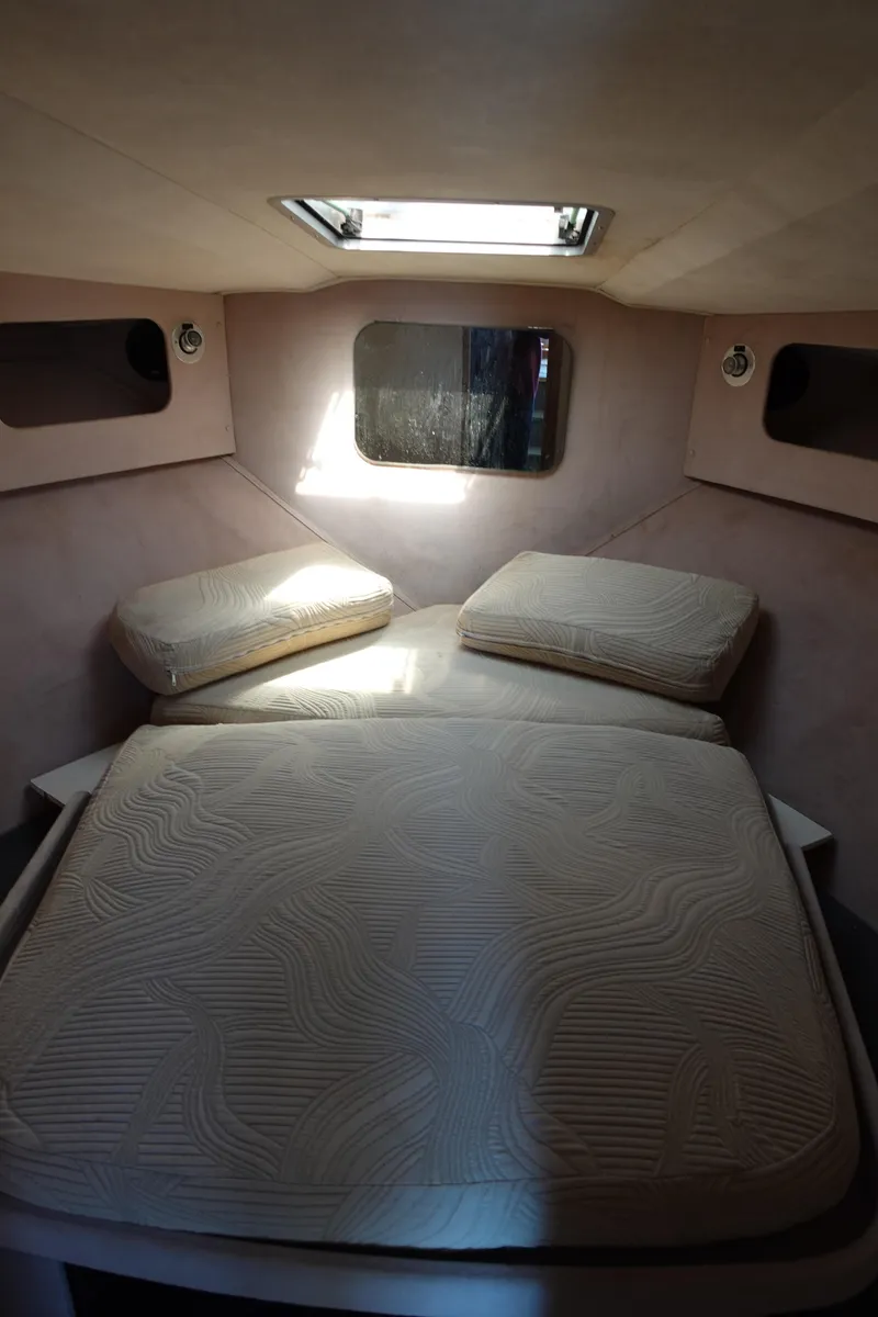 Slide: The Image of 1988 Trojan 10.8 Meter Sedan cabin interior with cushioned bed and overhead skylight. - 24