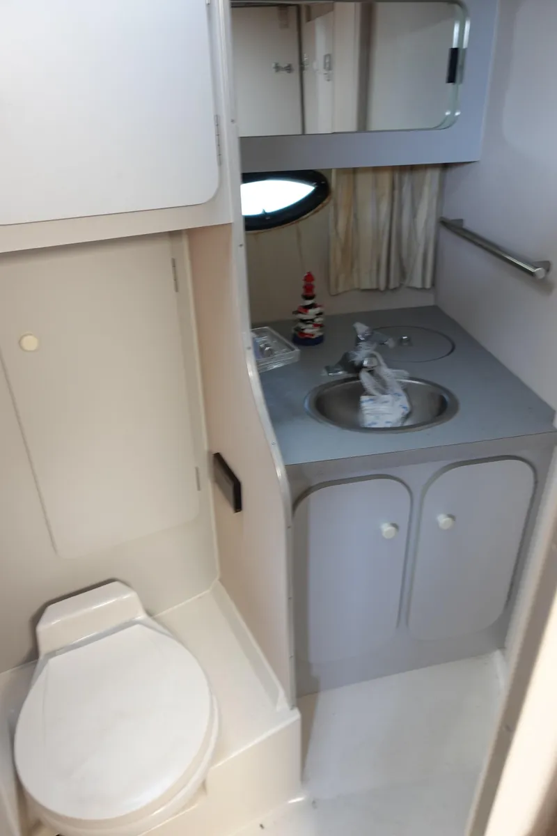 Slide: The Image of 1988 Trojan 10.8 Meter Sedan bathroom with sink, toilet, and mirror. - 25