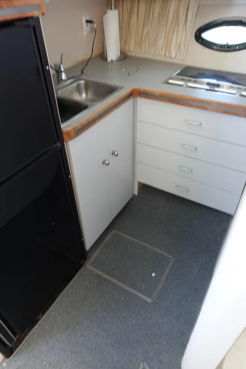 Slide: The Image of 1988 Trojan 10.8 Meter Sedan kitchen with sink, stove, and storage drawers. - 26