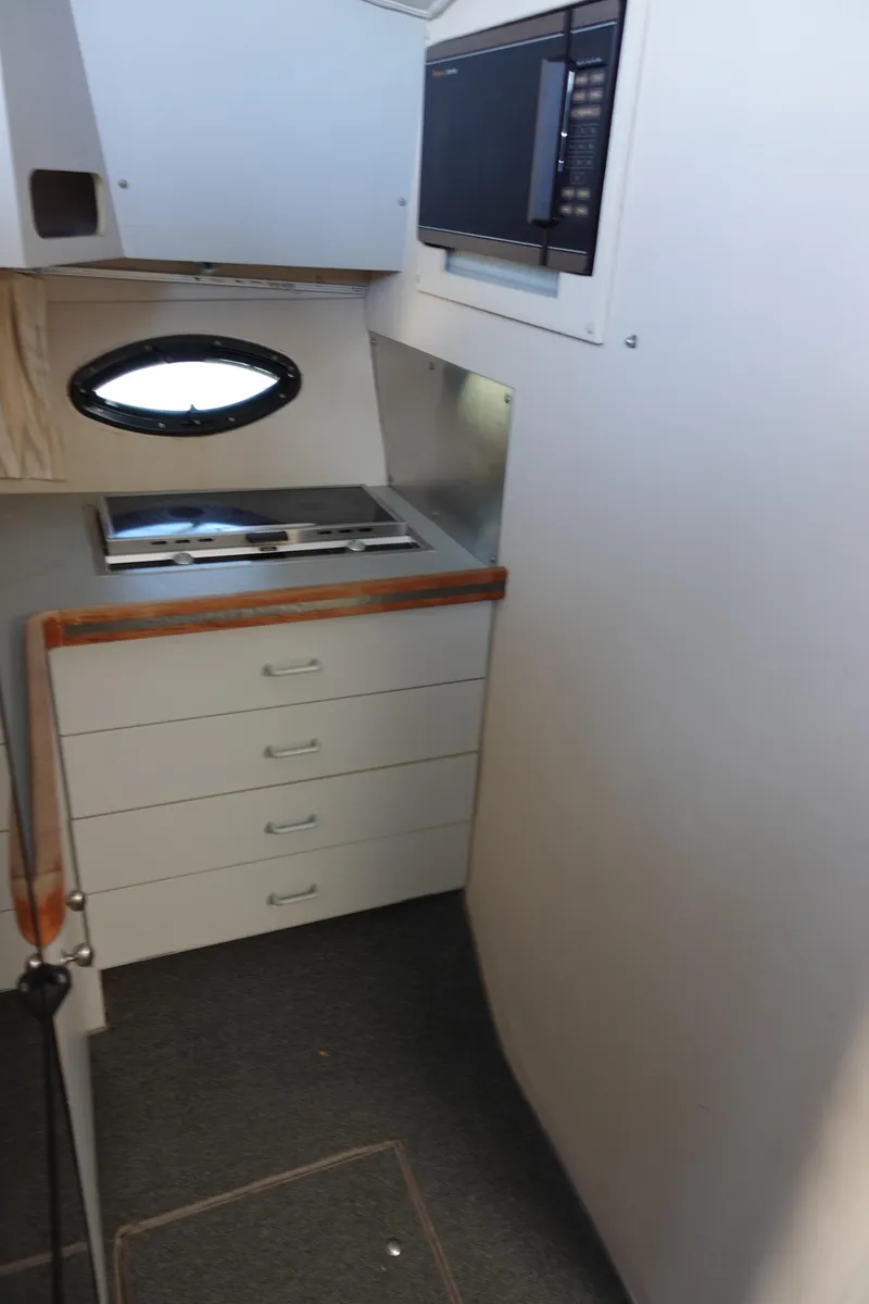 Slide: The Image of 1988 Trojan 10.8 Meter Sedan interior with kitchenette and storage drawers. - 28