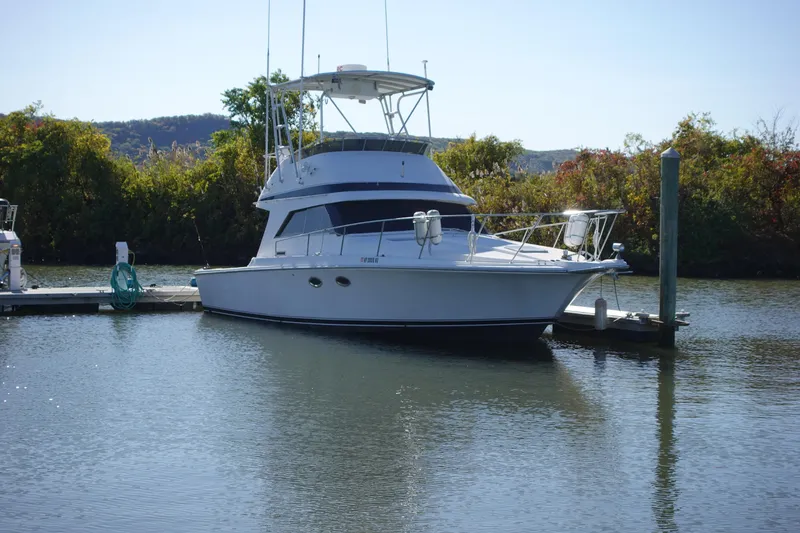 Slide: The Image of 1988 Trojan 10.8 Meter Sedan boat docked on calm water. - 3