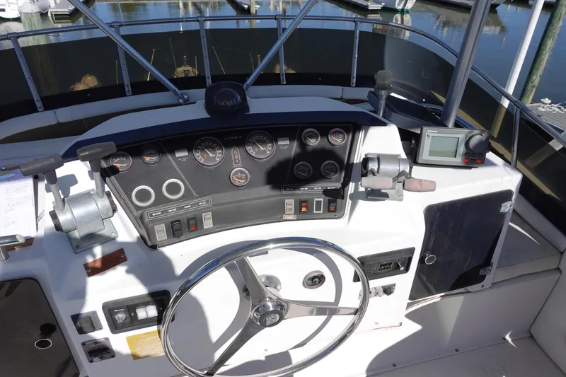 Slide: The Image of 1988 Trojan 10.8 Meter Sedan boat dashboard with steering wheel and navigation instruments. - 9