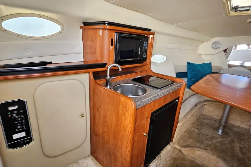 Slide: The Image of 2004 Rinker Fiesta Vee 250 cabin interior with kitchenette and seating area. - 12