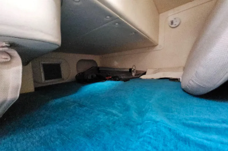 Slide: The Image of 2004 Rinker Fiesta Vee 250 cabin interior with blue carpet and seating. - 14