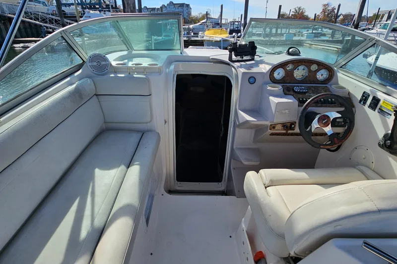 Slide: The Image of 2004 Rinker Fiesta Vee 250 boat interior with steering wheel and seating area. - 2