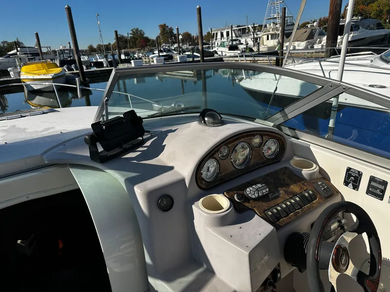 Slide: The Image of 2004 Rinker Fiesta Vee 250 boat dashboard at marina, showcasing controls and gauges. - 6