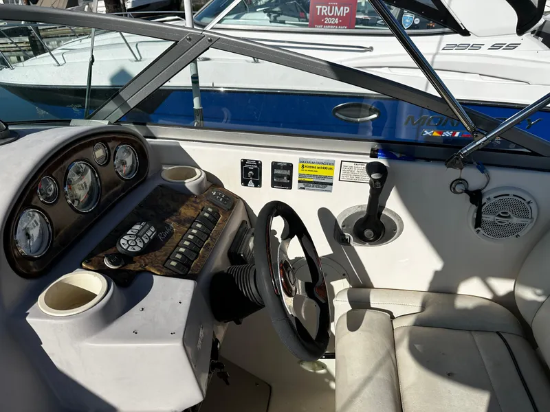 Slide: The Image of 2004 Rinker Fiesta Vee 250 boat cockpit with steering wheel and control panel. - 7