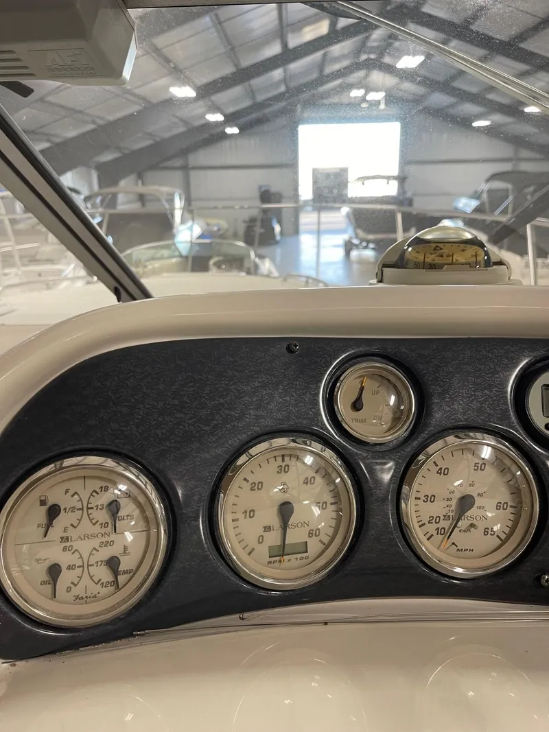Slide: The Image of Dashboard of a 1999 Larson 330 CABRIO boat with gauges in a marina. - 13