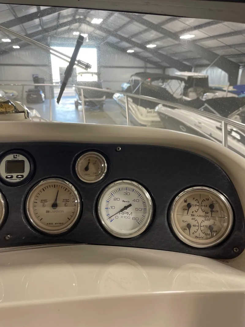 Slide: The Image of Dashboard of a 1999 Larson 330 Cabrio boat in a storage facility. - 14