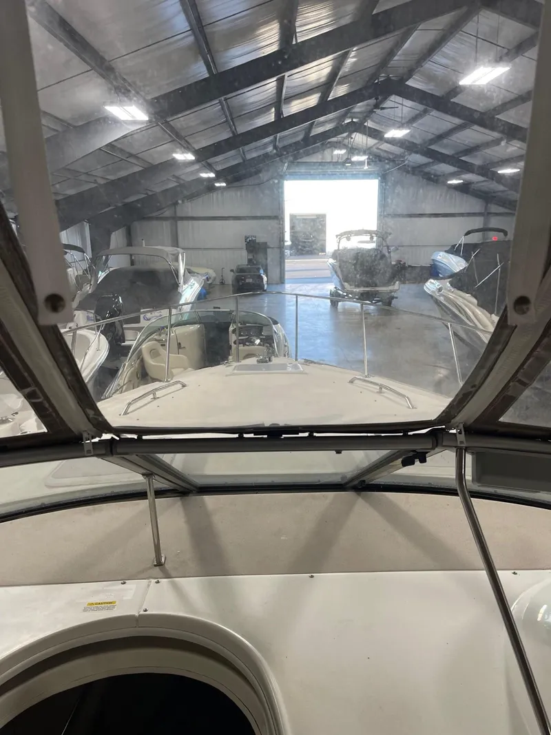 Slide: The Image of 1999 Larson 330 CABRIO in storage, surrounded by other boats in a large warehouse. - 21