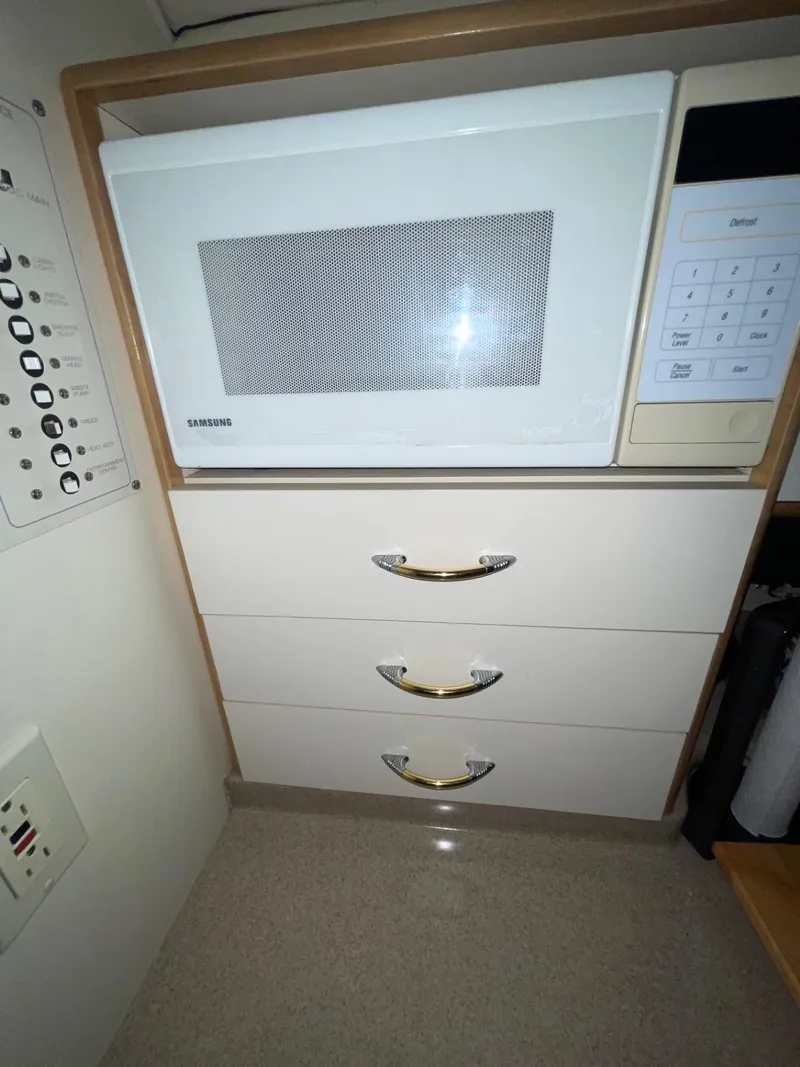 Slide: The Image of Microwave and drawers in 1999 Larson 330 CABRIO boat kitchen area. - 25