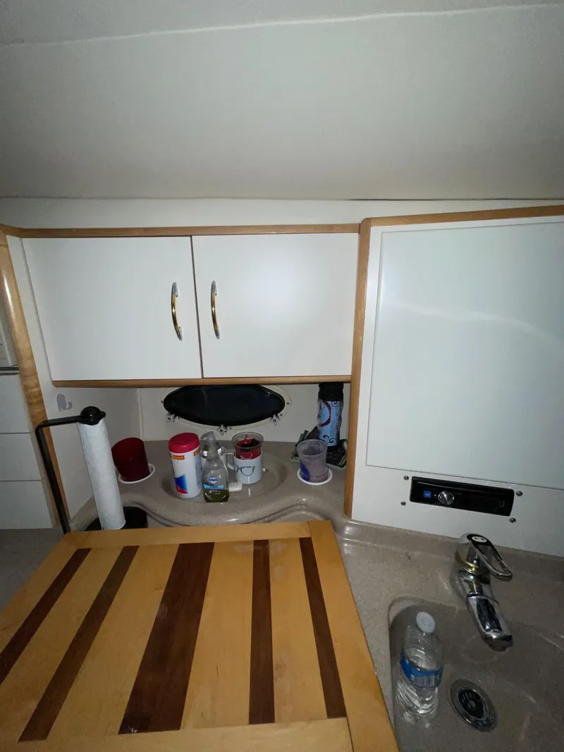 Slide: The Image of Interior of 1999 Larson 330 CABRIO boat kitchen with cabinets and sink. - 26