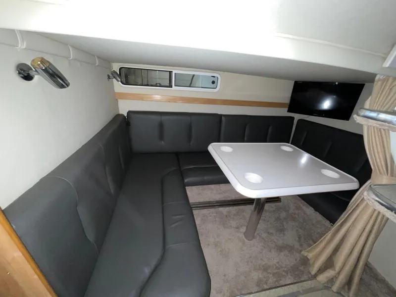 Slide: The Image of Interior of 1999 Larson 330 CABRIO with gray seating and dining table. - 30